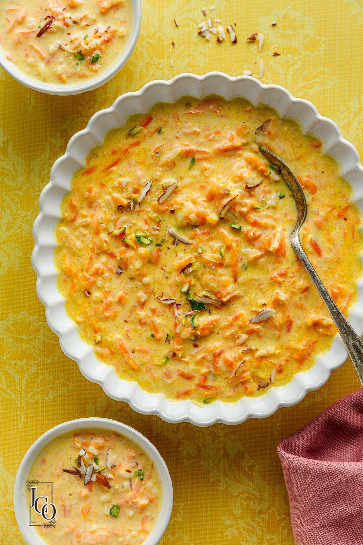 Carrot kheer also known as gajar ki kheer served in three bowls and garnished with chopped nuts.
