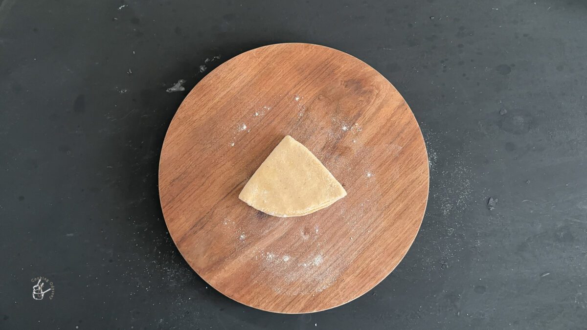 folded rolled dough on a wooden working board.