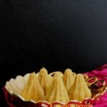 a gold bowl filled with ladoo in modak design