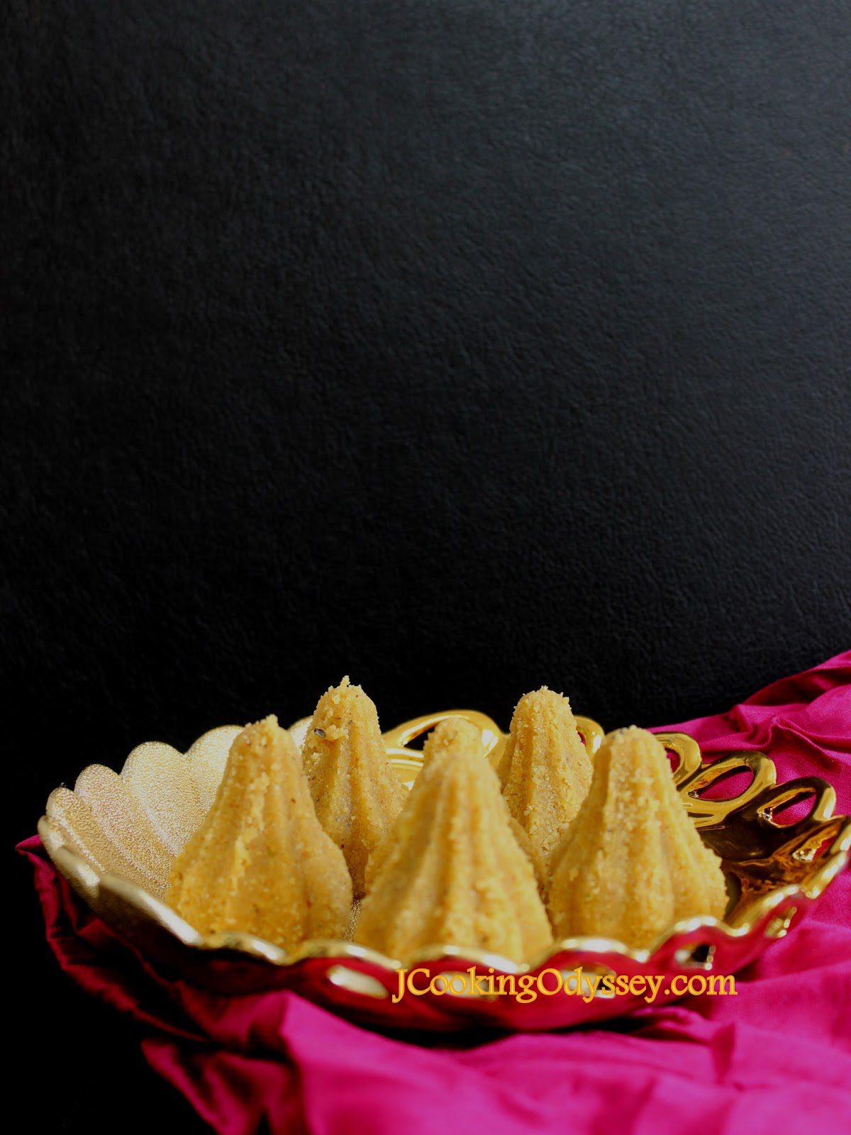 a gold bowl filled with ladoo in modak design