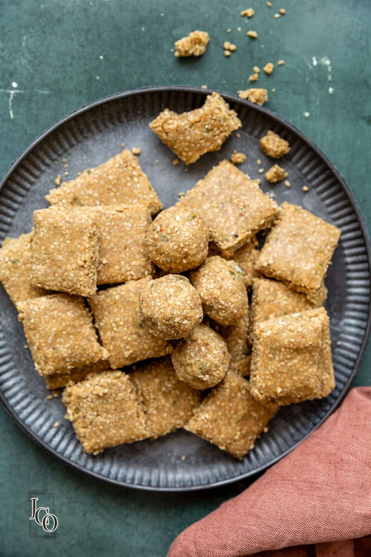 mixed seeds chikki with jaggery pieces on the plate.