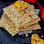 Bombay Ice and Golden Halwa pieces placed on a black slate