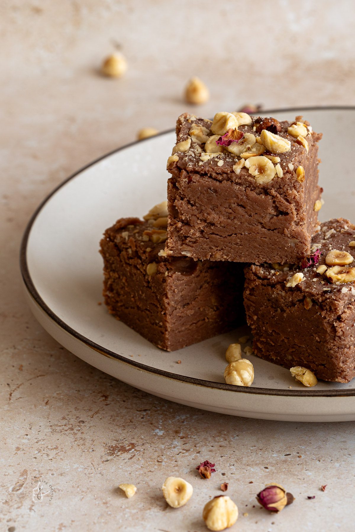 Three big pieces of Nutella Barfi placed on the round plate and decorated with chopped hazelnuts