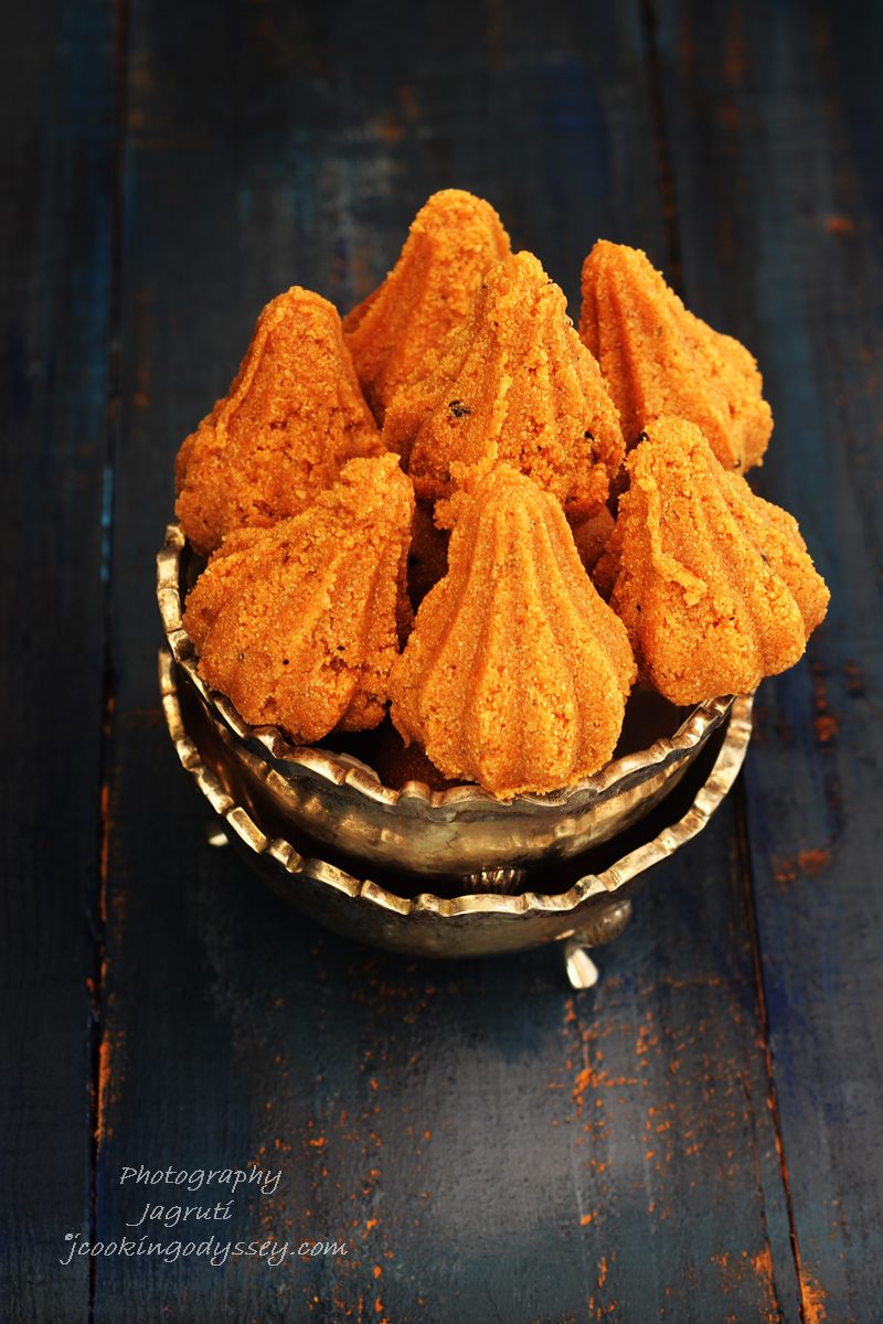 a gold bowl filled with 7 golden coloured modak