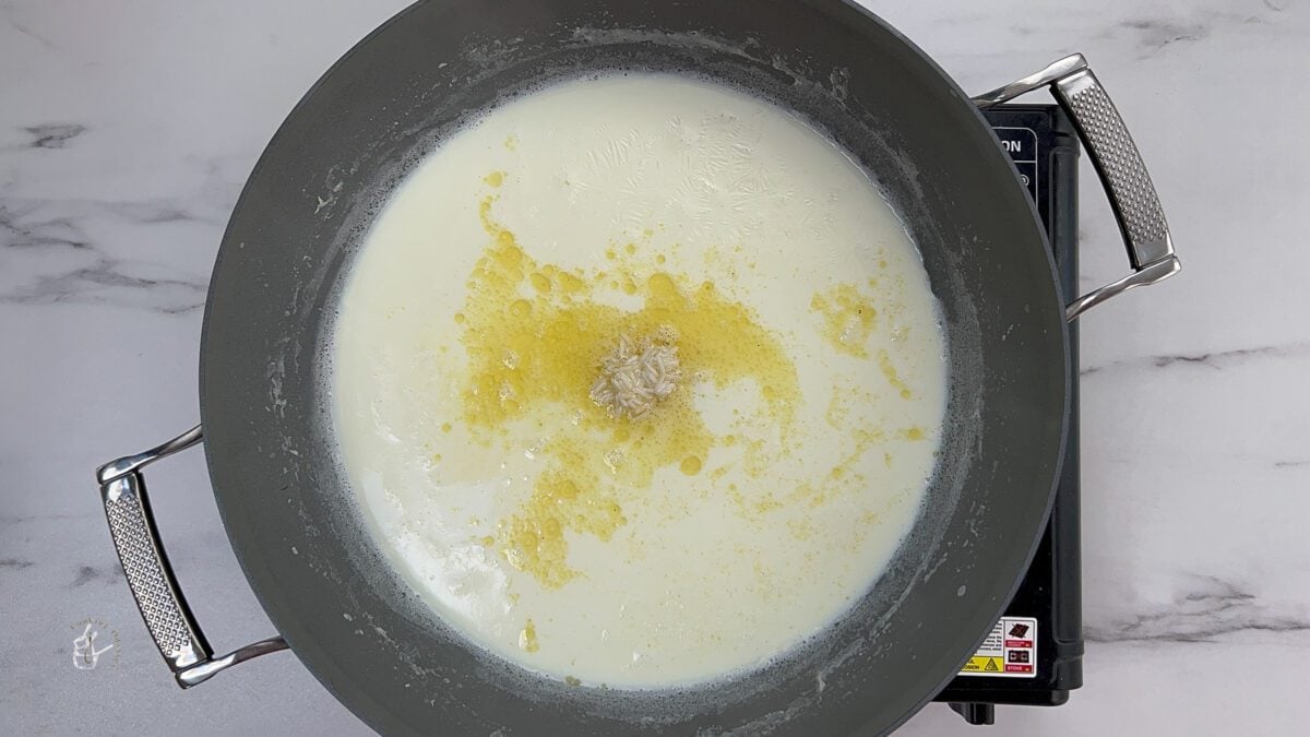 ghee coated rice added to the boiled milk to make doodh pak mithai