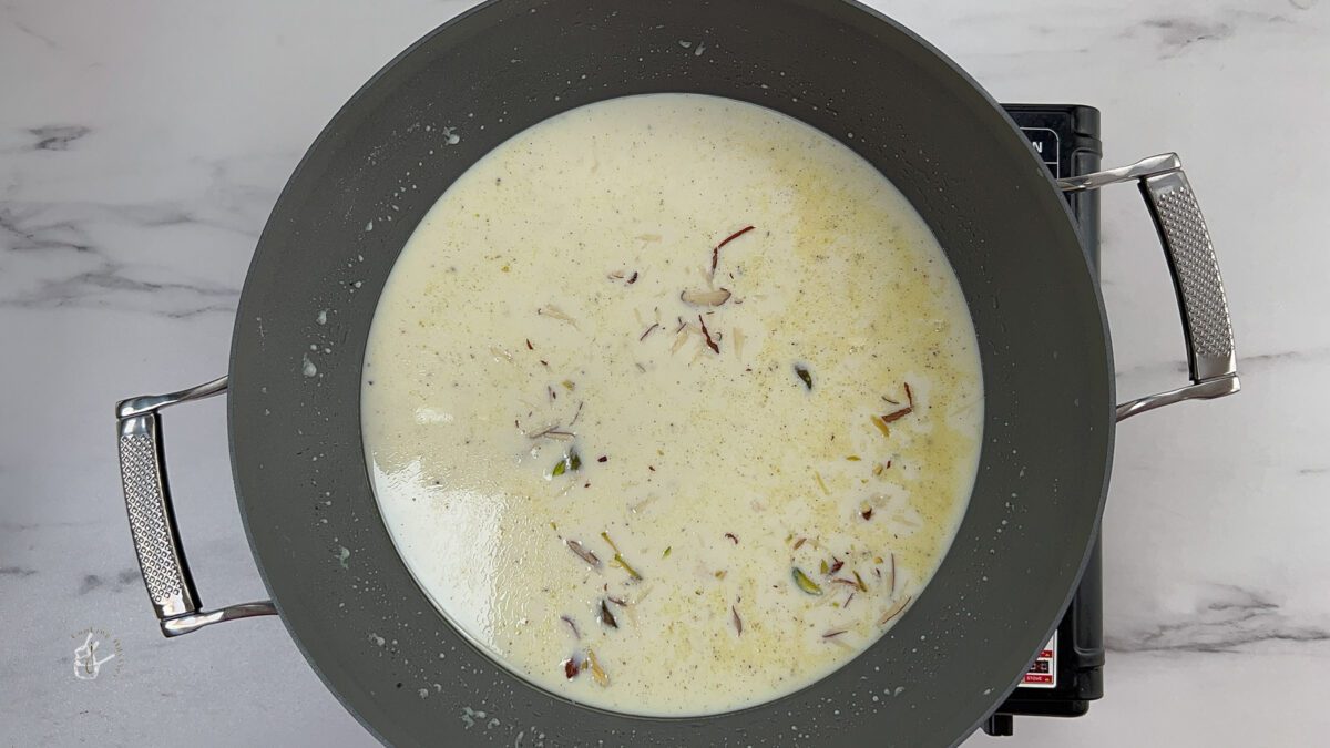 gujarati dudhpak recipe garnished with chopped nuts in the pan