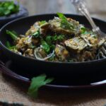 Farali patra served in a black bowl and garnished with freshly chopped cilantro