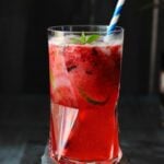 Virgin Mixed Berry Caipirinha served in a tall glass with a paper straw