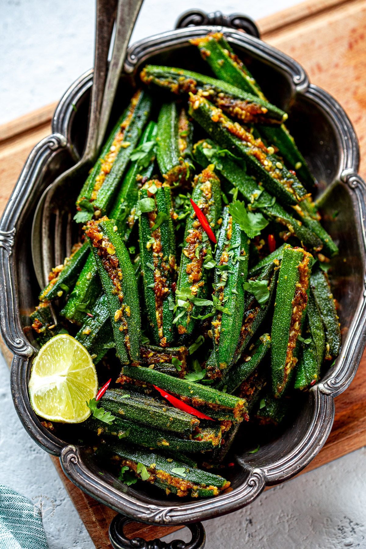 cooked stuffed okra curry arranged in a metal serving tray.