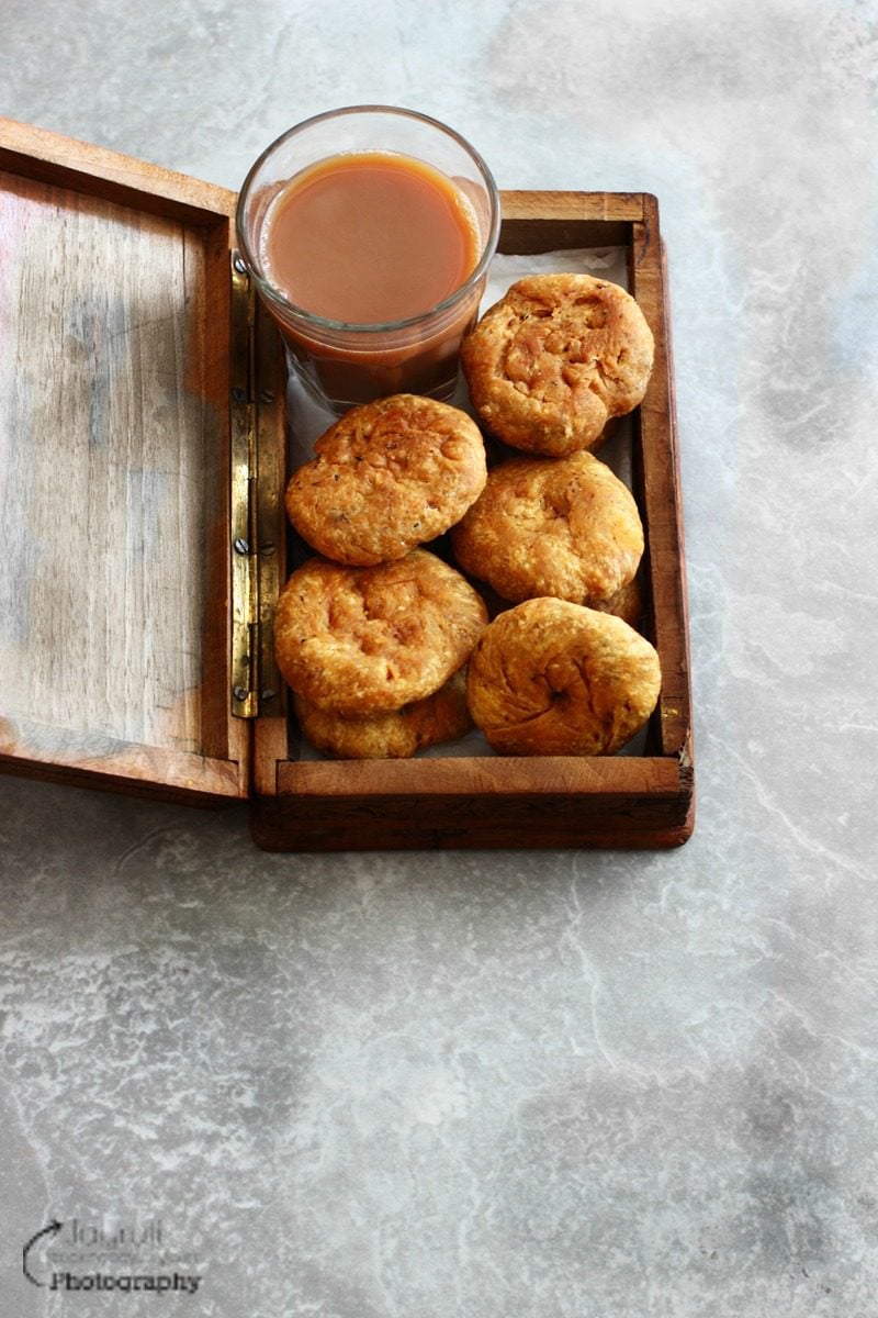 a rectangle box filled with masala khajali and served with a cup of masala chai
