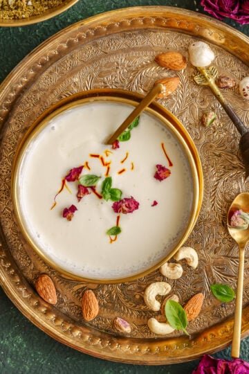 Panchamrut served in a bowl and ganished with rose petals, saffron and tulsi leaves.