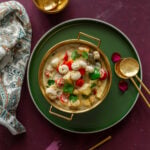 Indian white paneer curry served in a gold bowl, garnished with chopped coriander leaves.