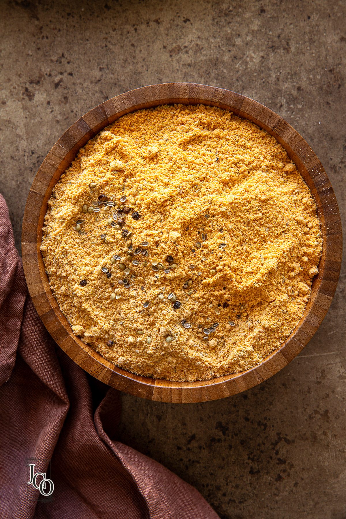 Crushed spices sprinkled on homemade dakor gota pre-mix in a bowl.