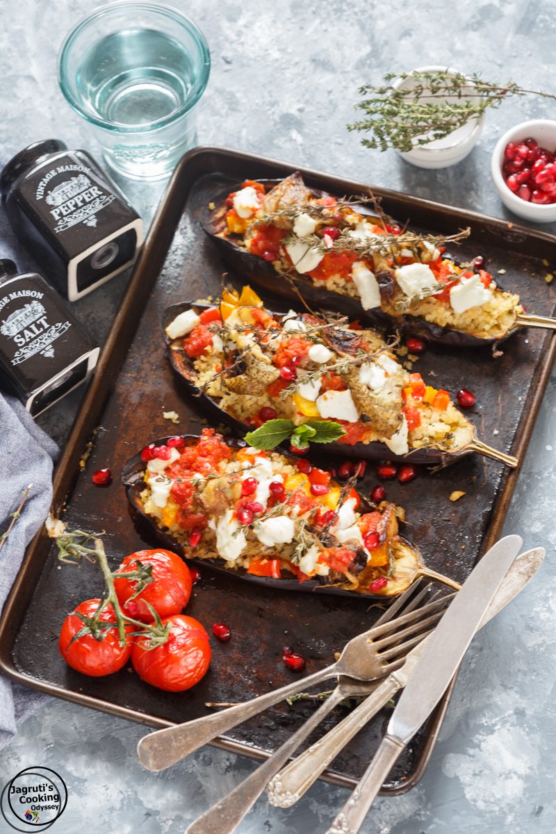 a baking tray with 3 cooked stuffed aubergines