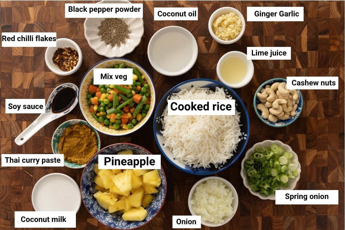 Cooked rice, pineapple pieces, thai curry paste, spices, soy sauce and mix veg in bowls.