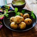 Moriyo vada placed in a plate next to green chutney bowl