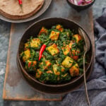 Dry saag paneer in a bowl with a serving spoon.