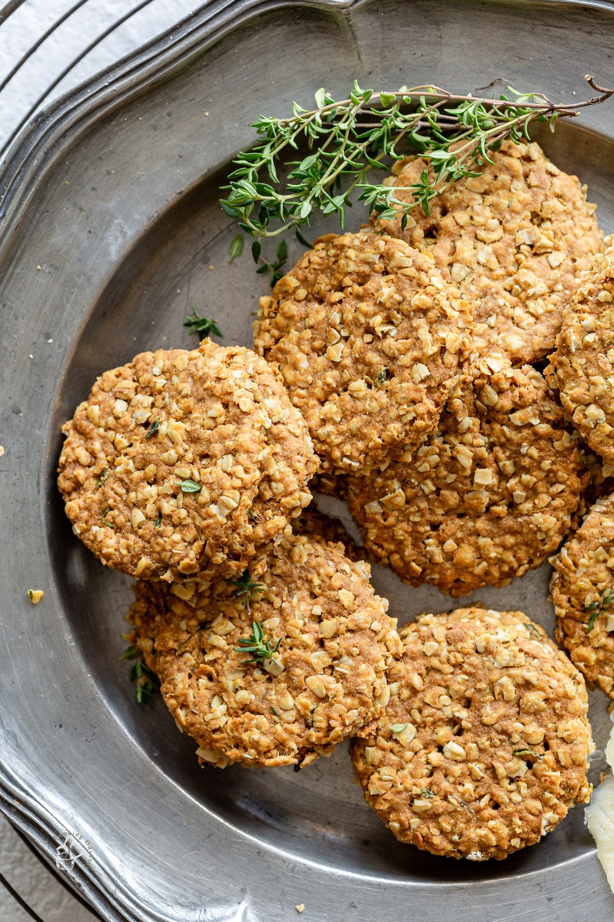 vegan scottish oatcakes with thyme on a pewter plate next to thyme sprigs