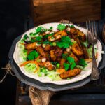 Masala mogo served in a plate topped with fresh salad