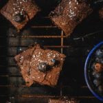 Coca cola brownies squares placed on a cooling wire rack.