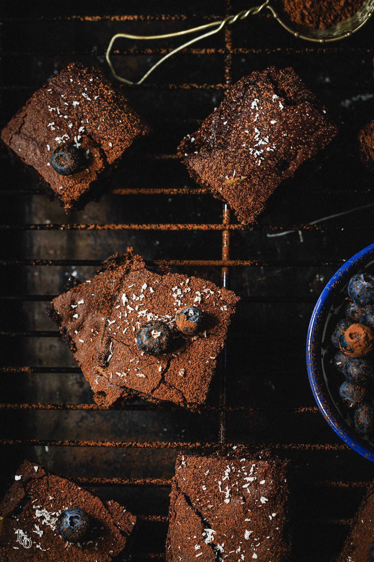 Coca cola brownies squares placed on a cooling wire rack.