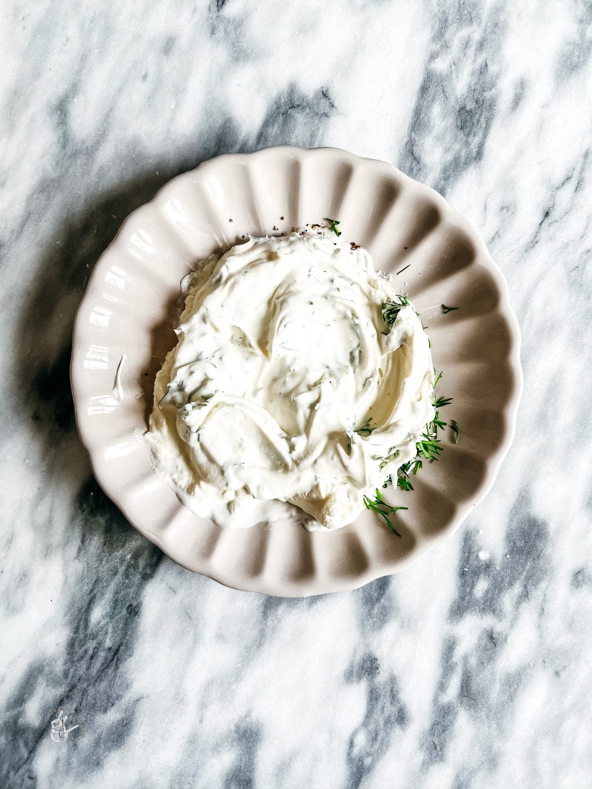 cream cheese spread in a bowl on a marble cutting board
