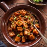 Tofu manchurian garnished with chopped spring onion.