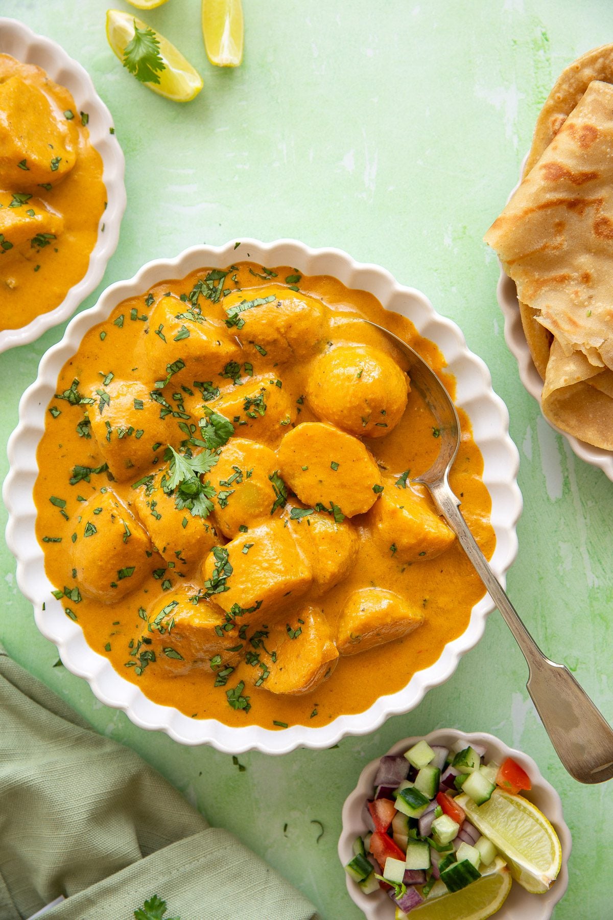 Indian potato curry with creamy sauce garnished with freshly chopped coriander leaves.