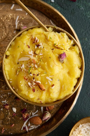 Two gold bowl of coconut halwa placed on a round thali.