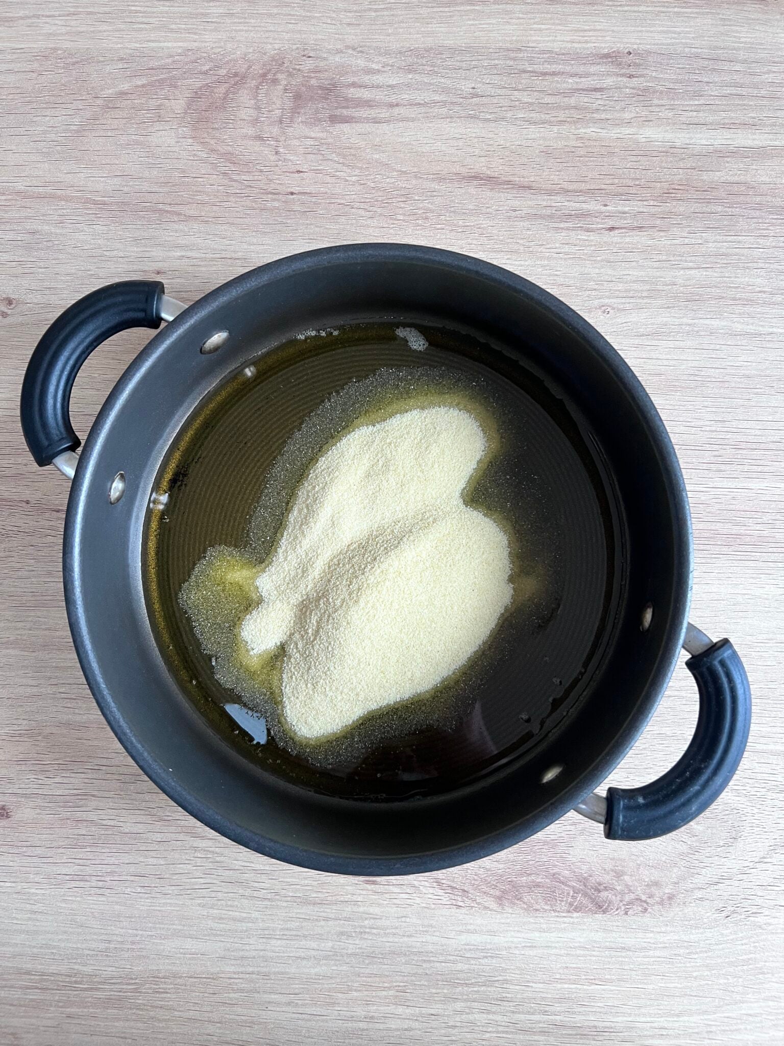 step by step sooji no siro recipe - melted ghee in a pan with semolina