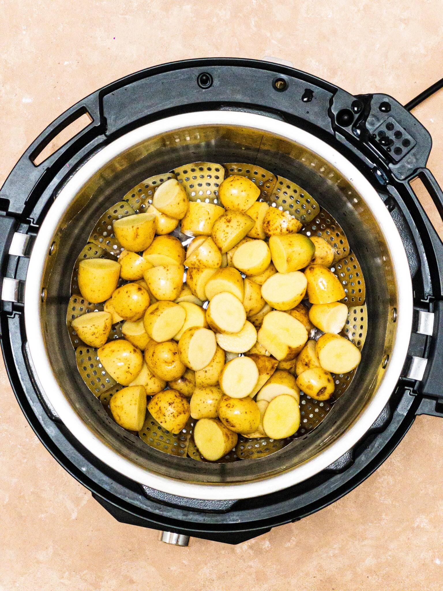 uncooked baby potatoes placed in a steamer instant pot  