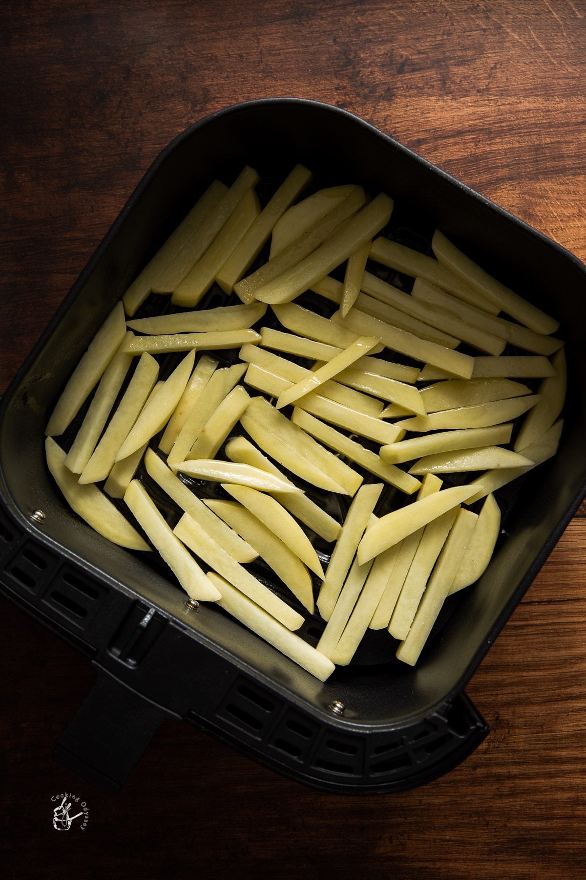 raw potato fries in the air fryer basket