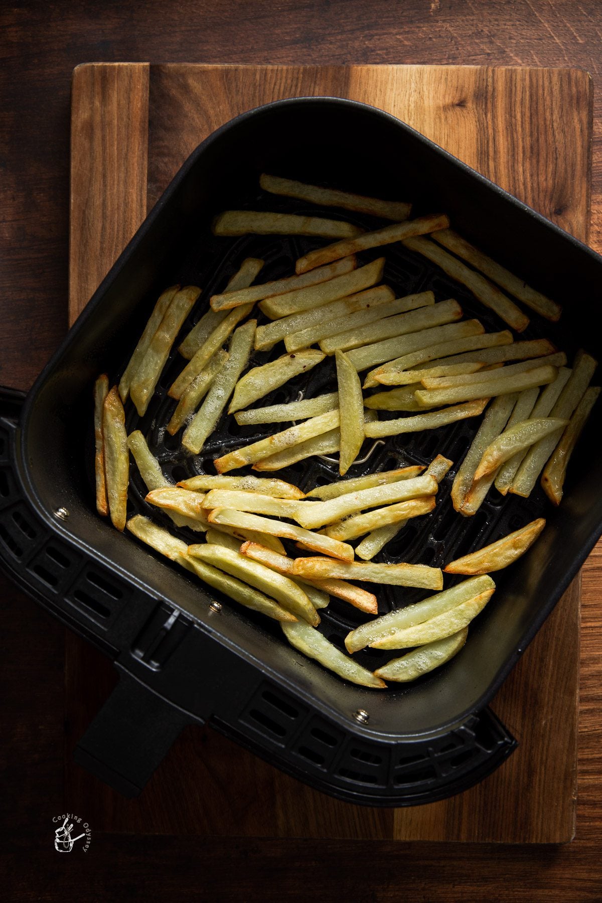 half cooked french fries in the air fryer basket