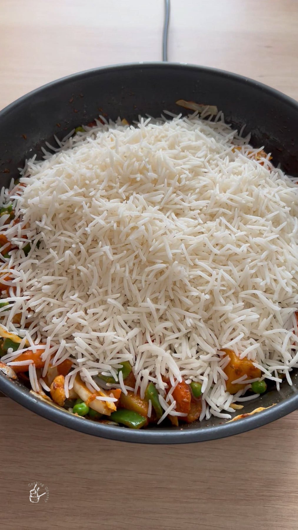 Cooked rice added to cooked vegetables.