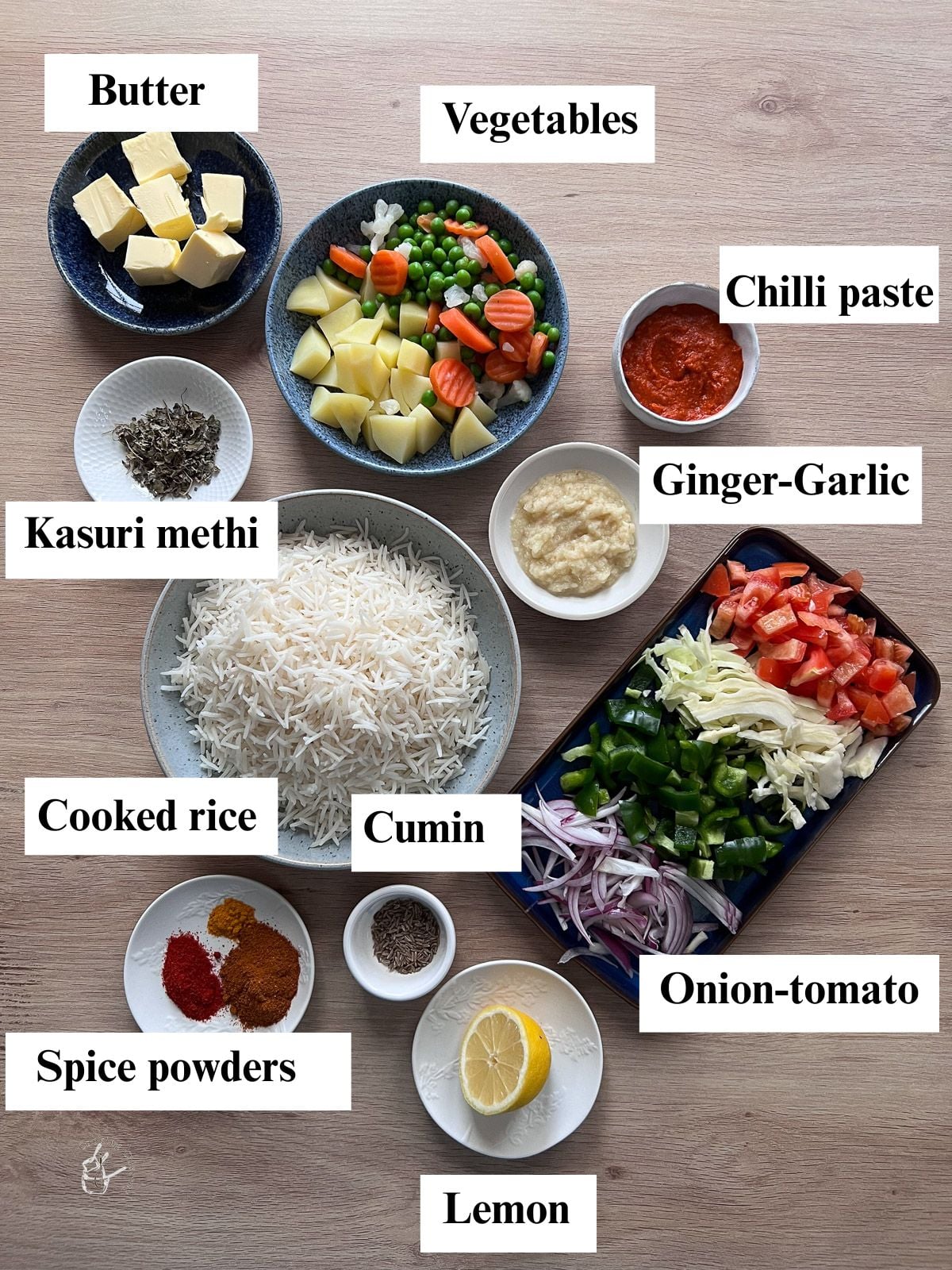 Cooked rice, vegetables, spices and butter in bowls. 