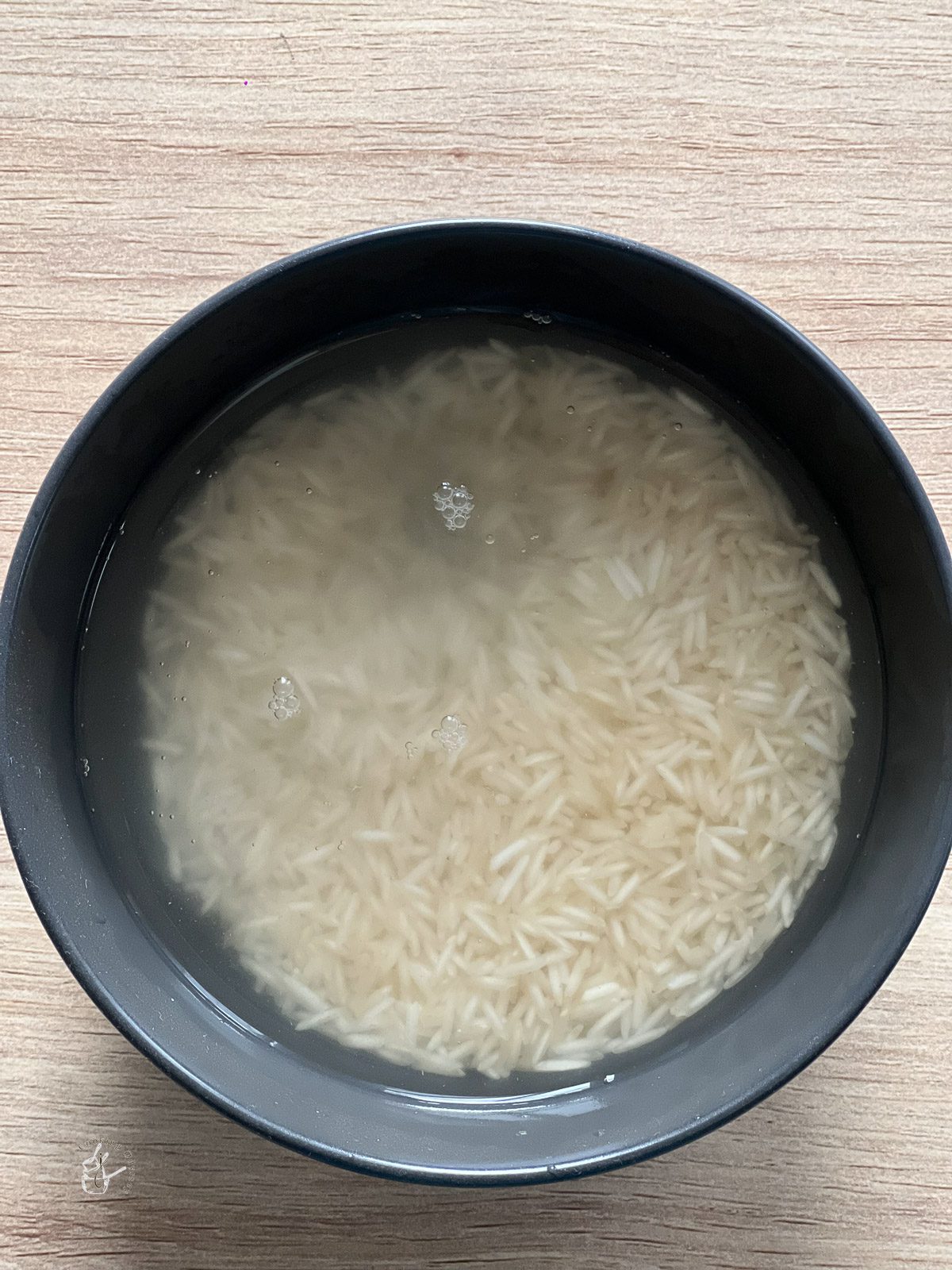 raw rice soaking in a bowl of water