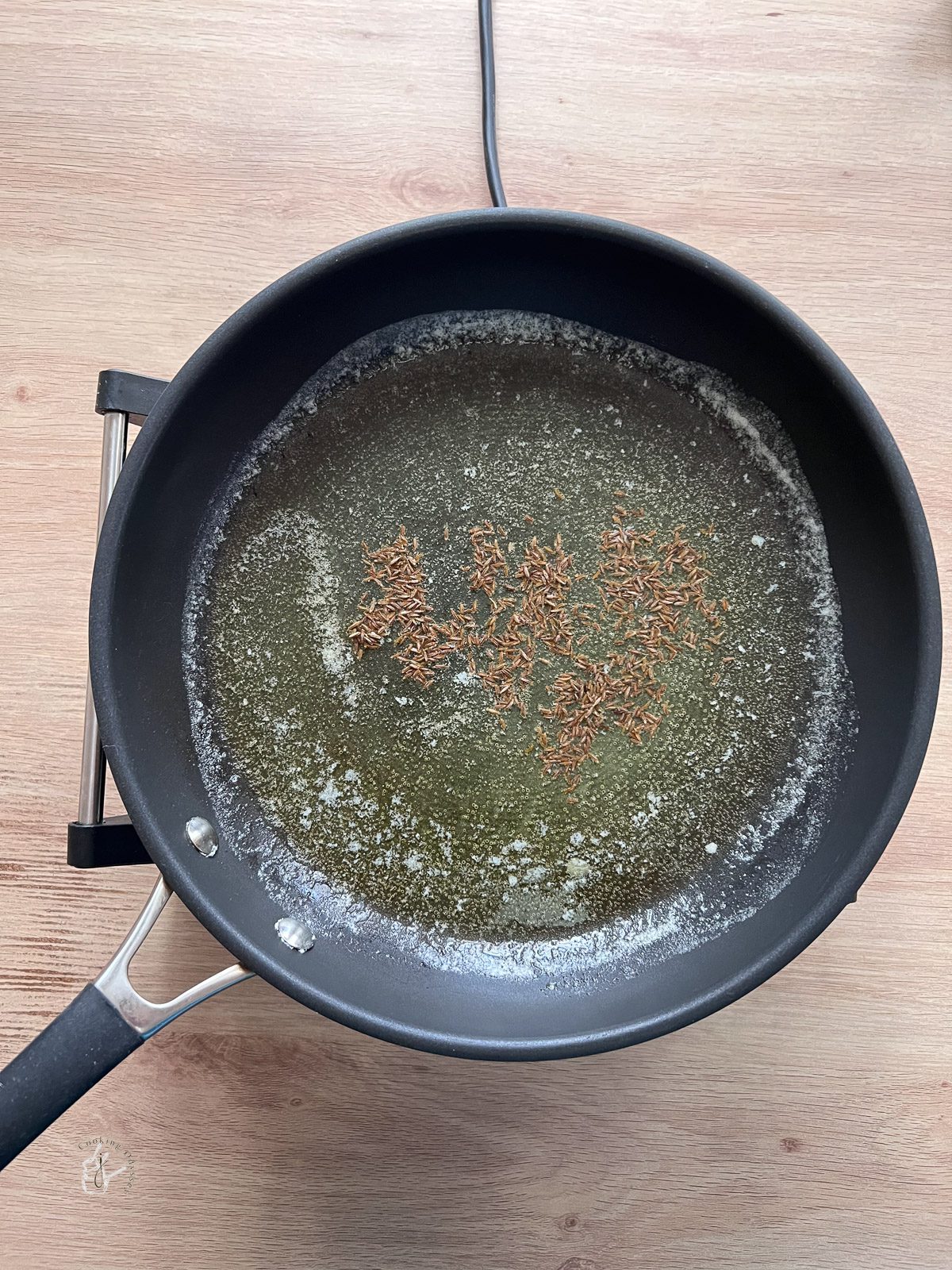 butter, oil and cumin seeds ina pan
