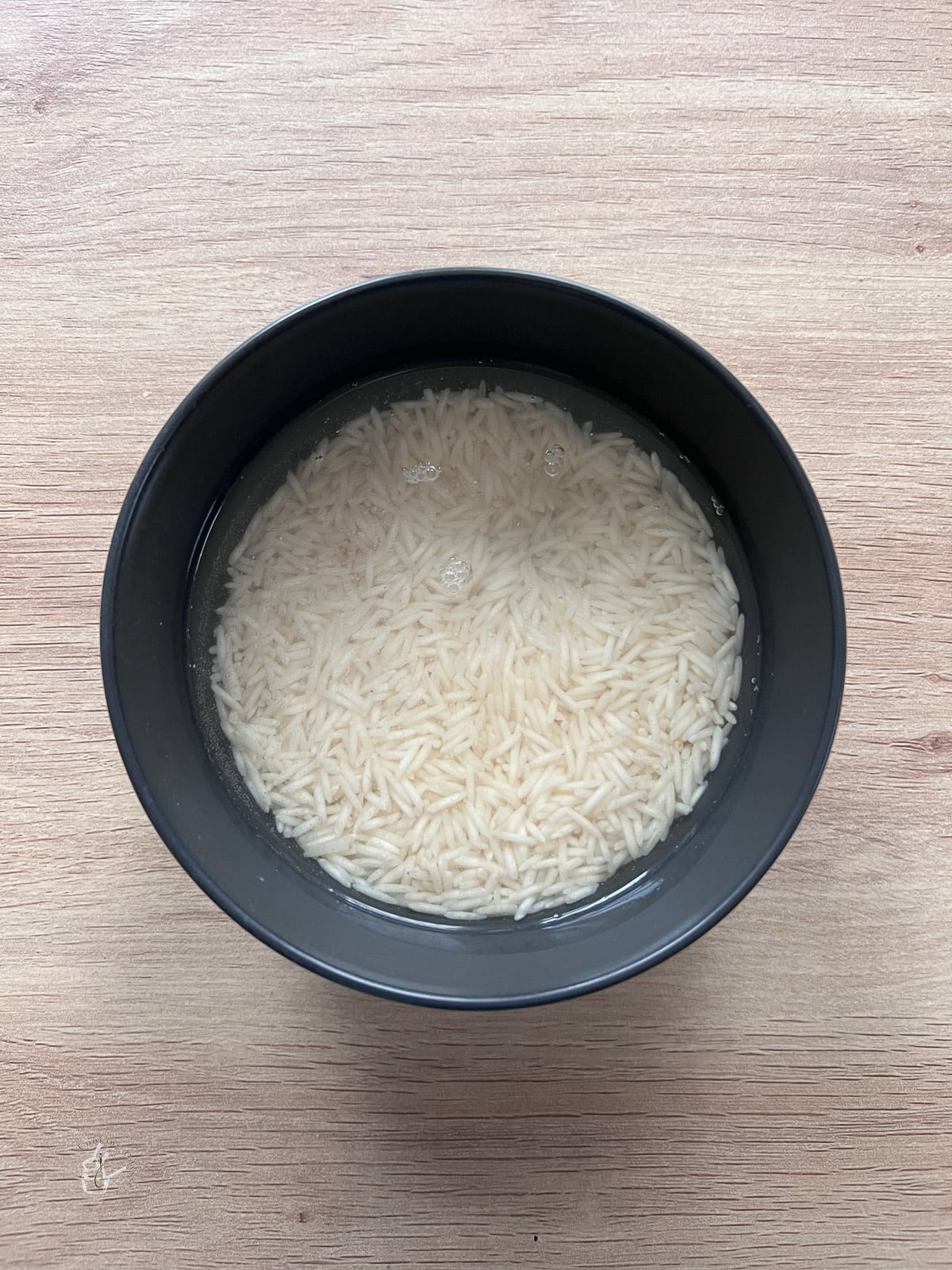 Rice soaking in water in a bowl. 