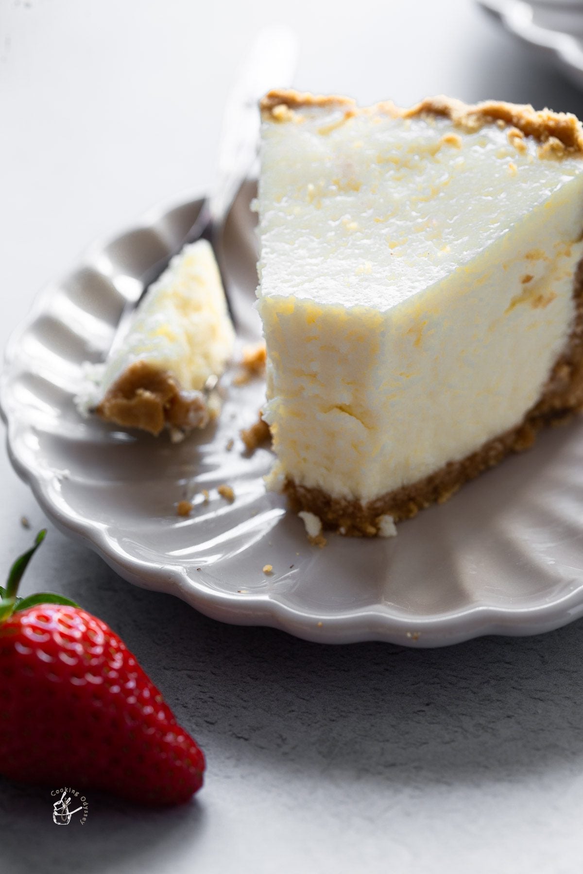 a bite is taken off from the slice of egg free new-york style cheesecake