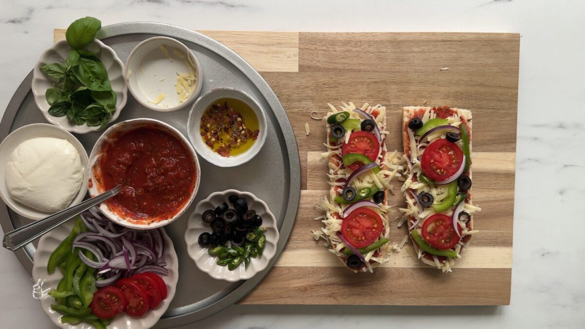 Pizza toppings such as tomatoes, olives and peppers on a bread slices