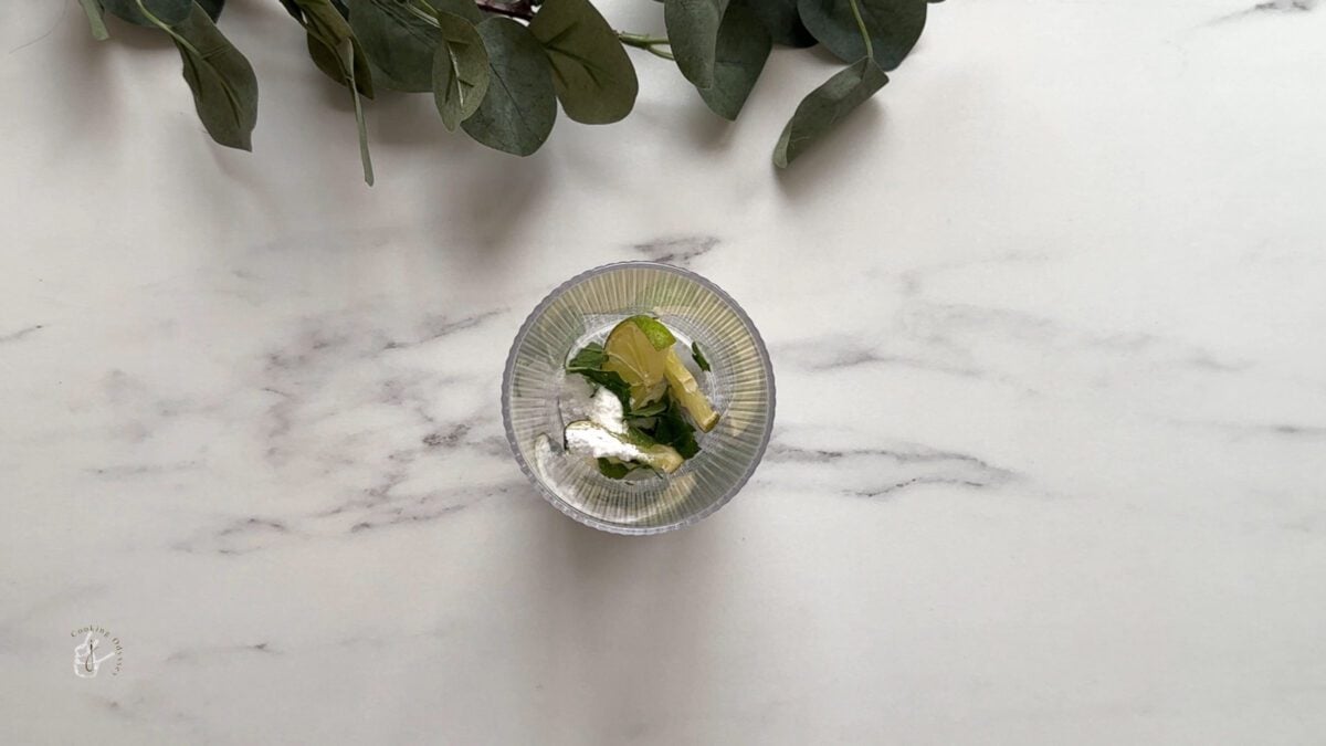 In a glass lime slices, mint and sugar 