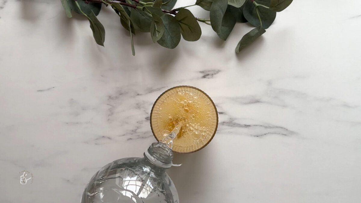 sparkling water added to the mango pulp and ice in the glass