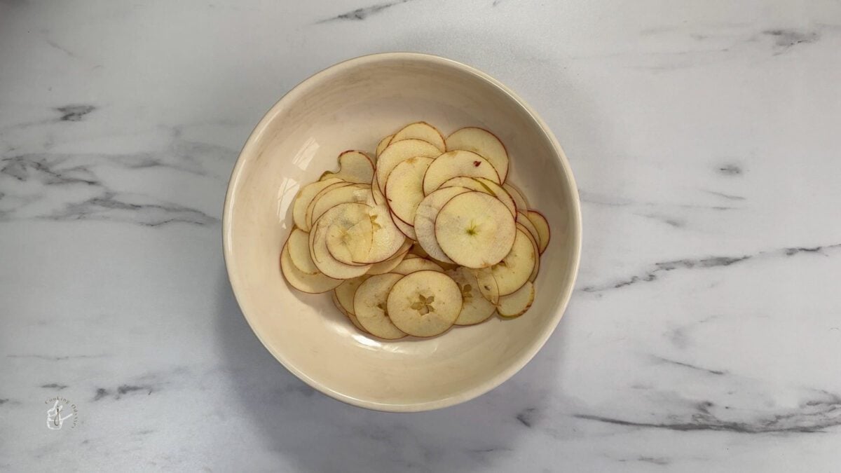 sliced apples in a beige round bowl