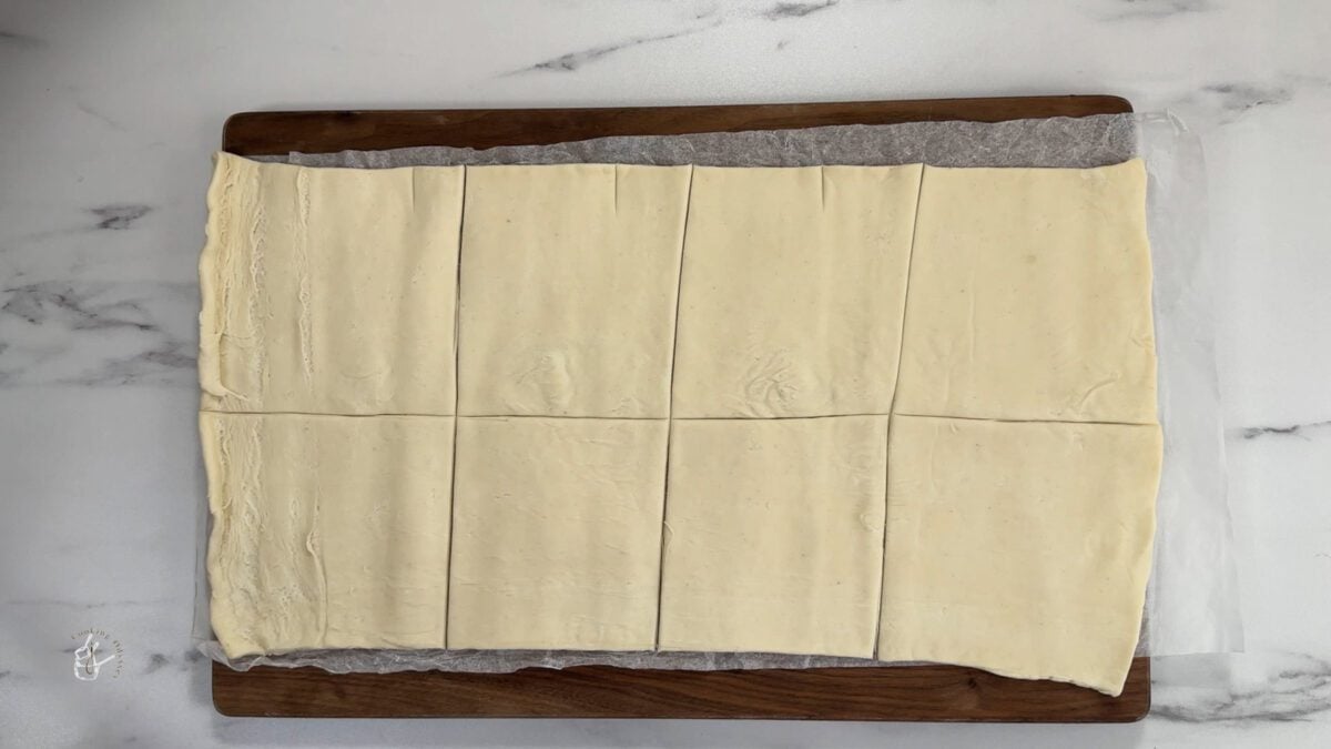 raw puff pastry cut into small squares on a board