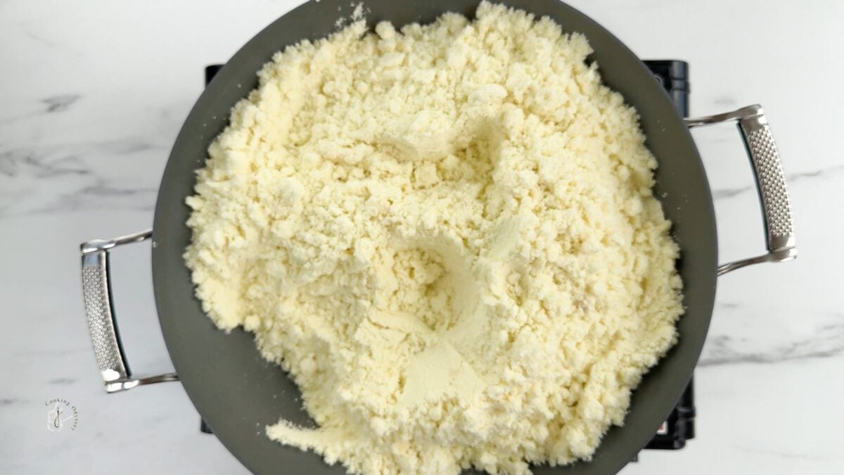 roasted milk powder in a pan to make tri colour barfee 