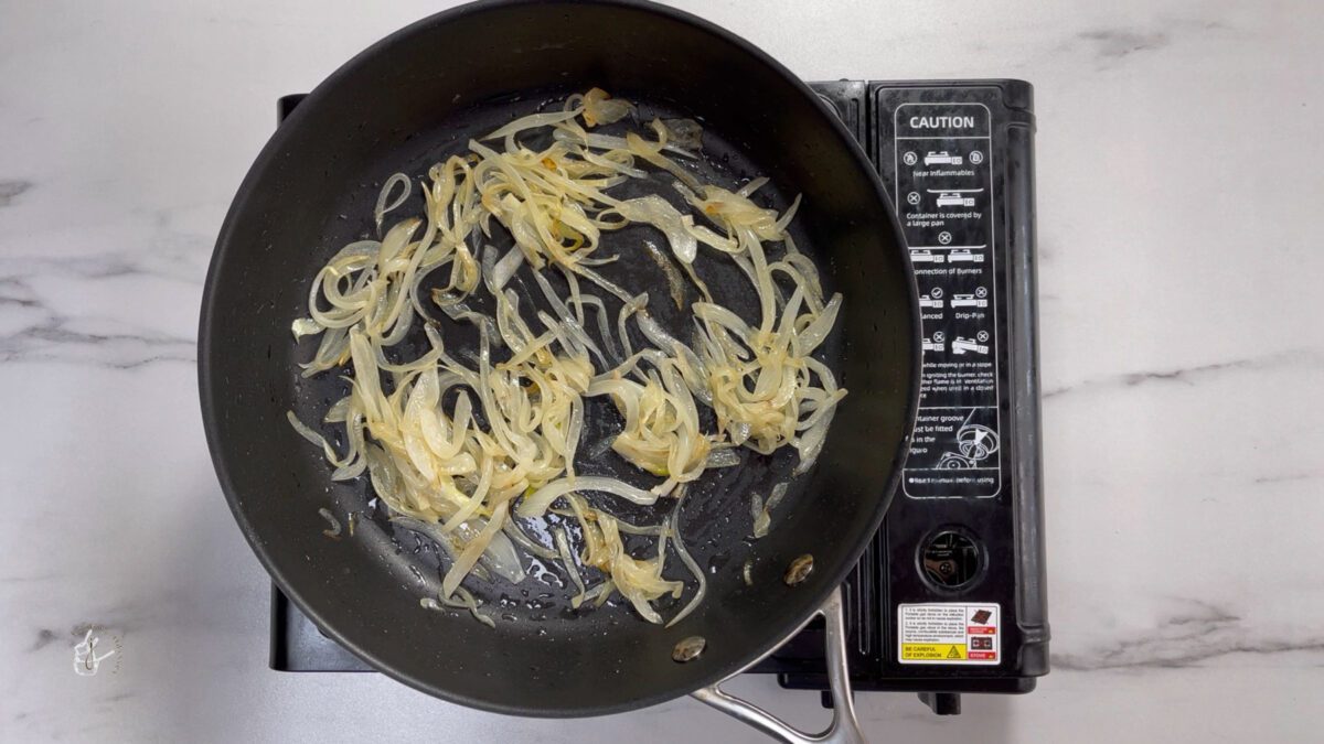 half cooked onion slices in a pan