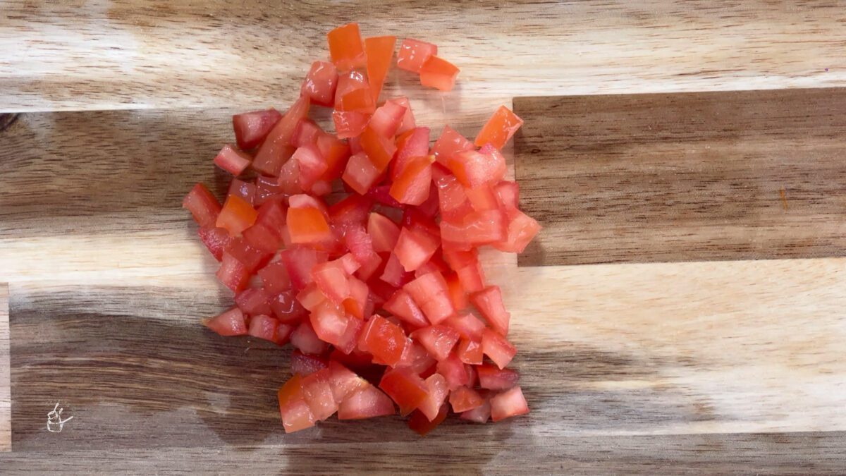 finely chopped red tomatoes on a wooden chopping board