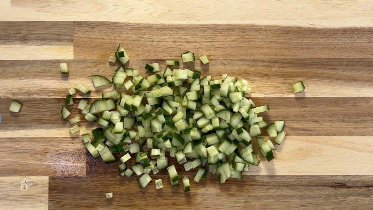 finely chopped english cucumber on a wooden chopping board 