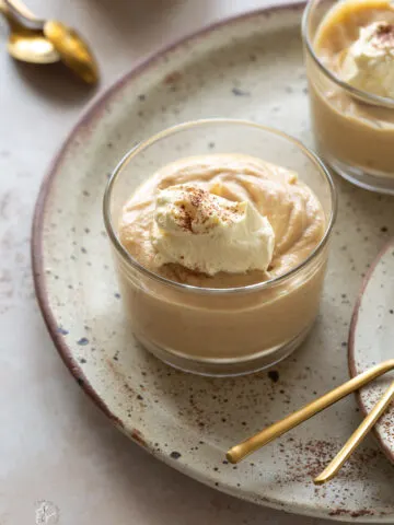 Three small pots of peanut butter mousse placed on a beige plate