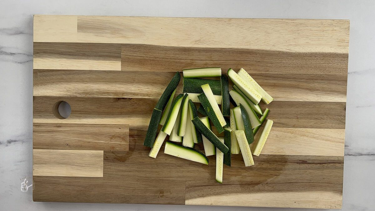 Cut Zucchini strips on the wooden chopping board